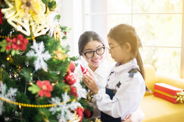 Sister make a christmas gift box to younger sister for xmas holidayHappy and smiling together