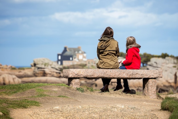 The sisters are sitting on the shore of the ocean