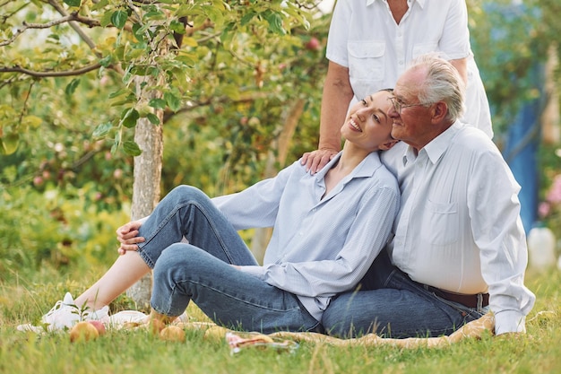 Sitting on the ground Daughter is with her senior mother and father is in the garden