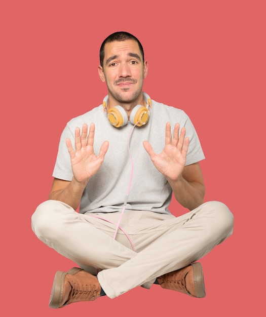 Sitting young man doing a gesture of stop