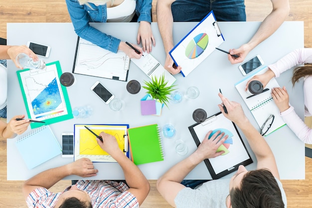 The six people work at the table. view from above