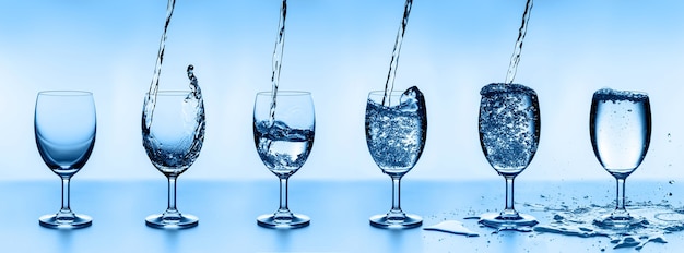 Six water glasses of water, arranged in ascending order.