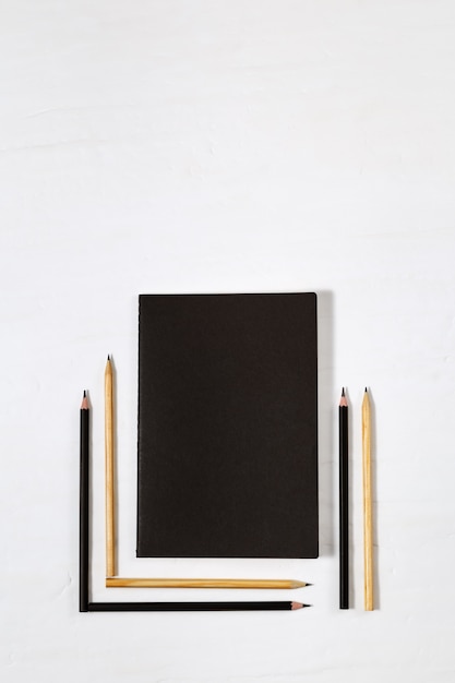 Six wooden pencils and closed black book