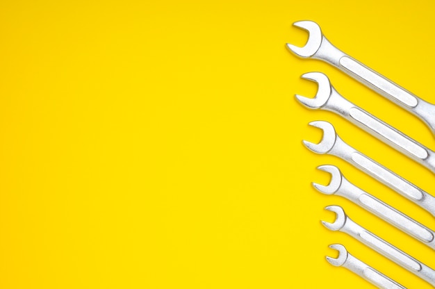 Six wrenches on a yellow with space for text and design