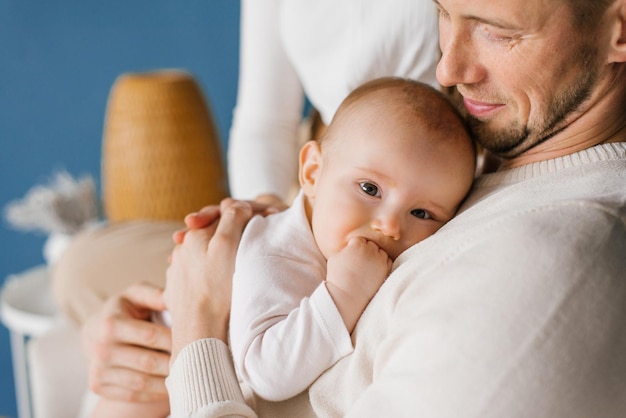 Sixmonthold baby son in the arms of his happy father