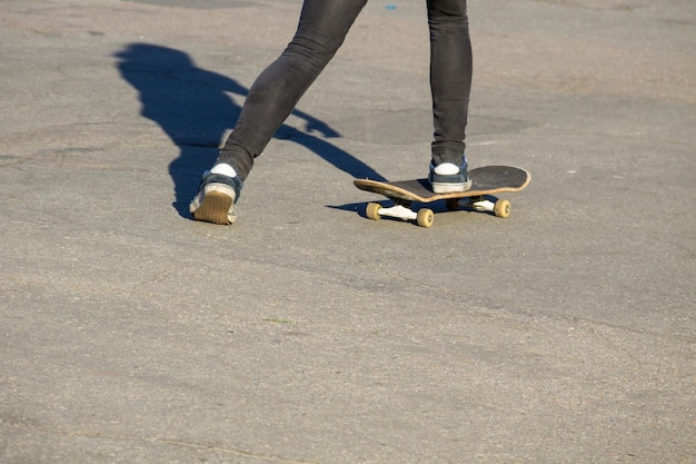 Skateboarder legs riding skateboard at skatepark