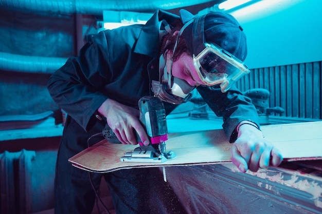 Skater in process of making his own skateboard, longboard