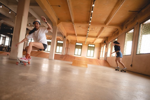 Skater woman person playing skateboard in sport gym young Asian woman are happy and fun with skateboarding lifestyle in city teenage hipster female trendy fashion