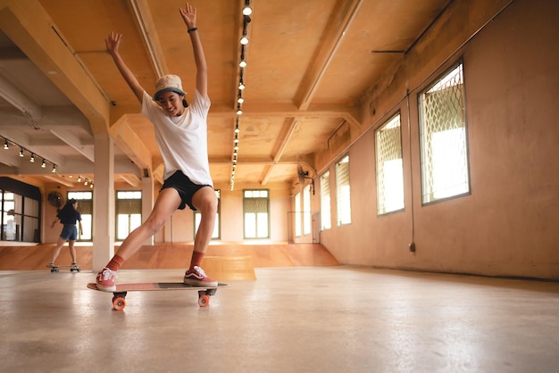 Skater woman person playing skateboard in sport gym young Asian woman are happy and fun with skateboarding lifestyle in city teenage hipster female trendy fashion