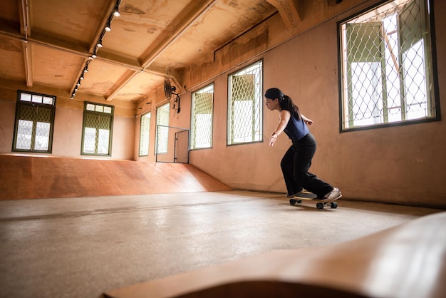 Skater woman person playing skateboard in sport gym young Asian woman are happy and fun with skateboarding lifestyle in city teenage hipster female trendy fashion