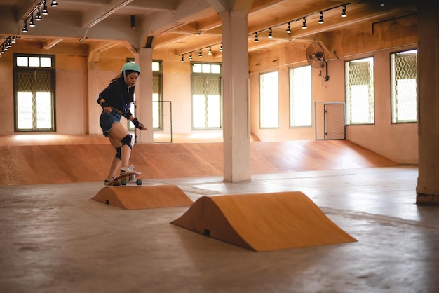 Skater woman person playing skateboard in sport gym young Asian woman are happy and fun with skateboarding lifestyle in city teenage hipster female trendy fashion