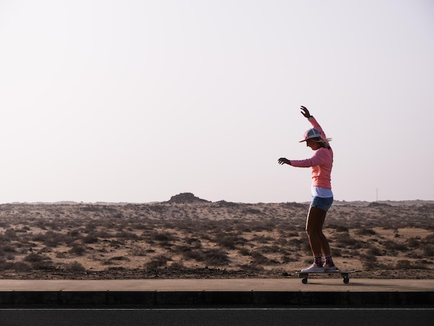 Skater woman riding surfskate by the desert