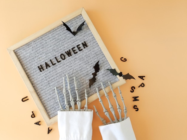 the skeleton's hands collect the word HALLOWEEN in a frame