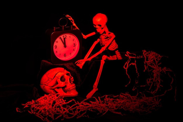 A skeleton waking up crawling out of the grave and turning off the alarm clock a skull on a black background tinted in red