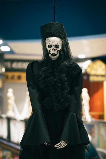 Skeleton of a woman in a black dress and hat indoors decorations for Halloween