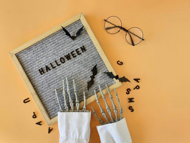 The skeletons hands collect the word Halloween from the letters