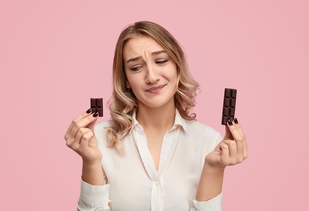 Skeptical woman looking at sweet chocolate