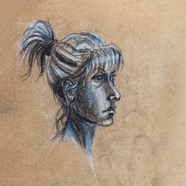 Sketch of beautiful woman drawing by hands with black and white chalk and charcoal on beige textured paper Side portrait of girl with hair bun