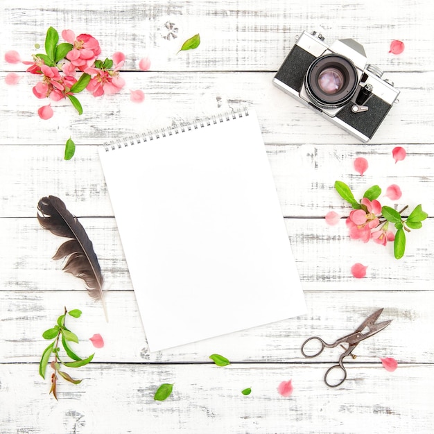 Sketchbook photo camera spring flowers floral flat lay