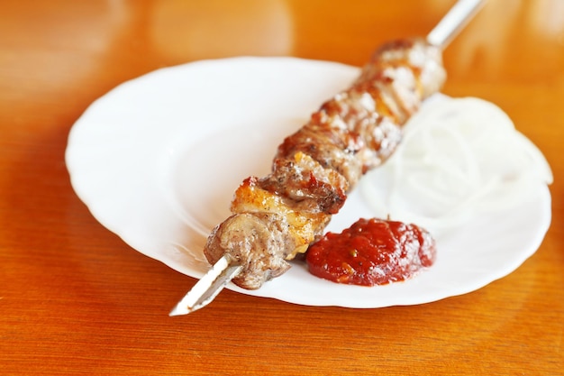 Skewer of lamb shishkebab close up on white plate