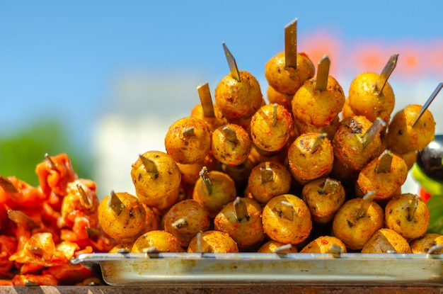 Skewers with whole potatoes put on.