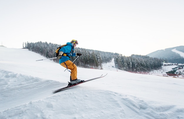 Skier man at jump from the slope of mountains