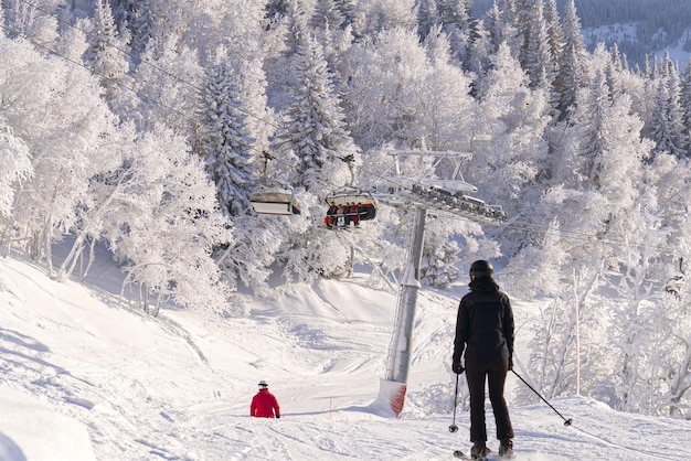 Skier in mountains prepared piste and sunny day winter leisure sport and people concept