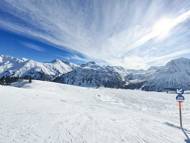 A skier on a ski slope with mountains in the background