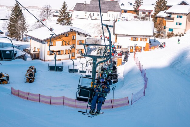 Skiers riding chairlifts at ski resort during beautiful sunny day