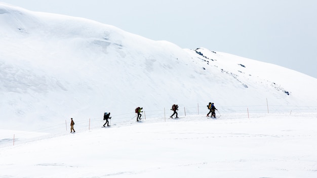 Skiers walking on snow covered mountain ranges