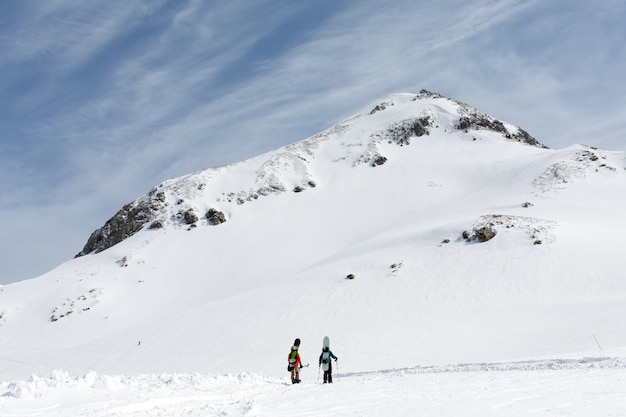 Skiers walking on snow covered mountain ranges