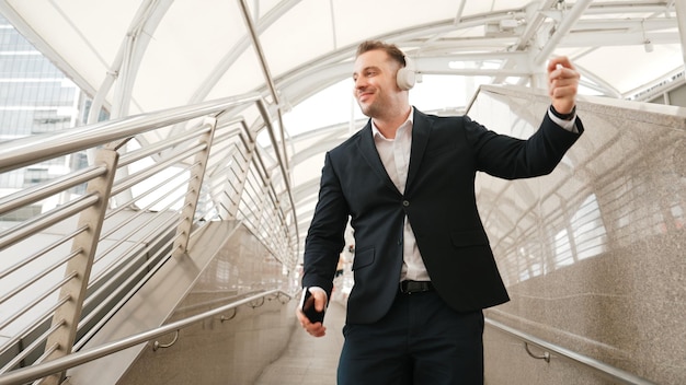 Photo skilled business man dance to music from headphone at modern corridor urbane