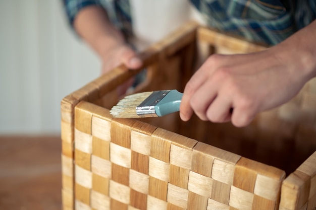 Skilled carpenter painting the outside of the box