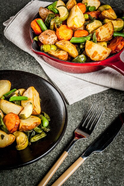 Skillet with  fried seasonal autumn vegetables (zucchini, potatoes, carrots, beans)