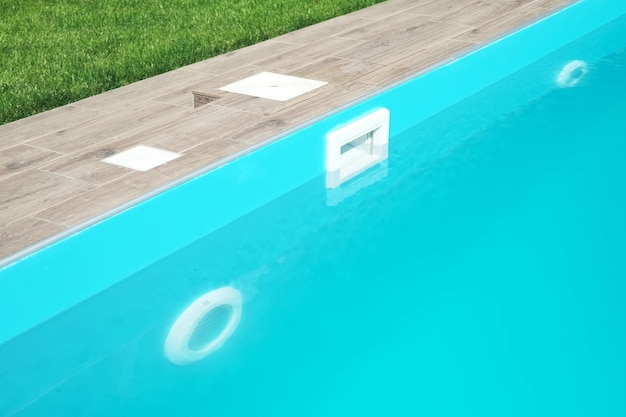 Skimmer and LED lighting in a blue pool in a country house Clear blue water in the pool Relax in the backyard of a country house