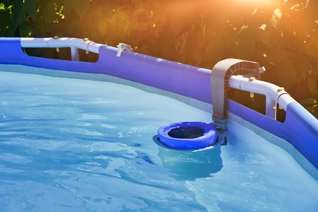 Skimmer on a round frame pool of a country house Blue skimmer to clean pool in clear water