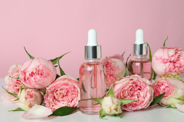 Skin care concept with essential rose oil on pink background