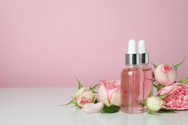 Skin care concept with essential rose oil on pink