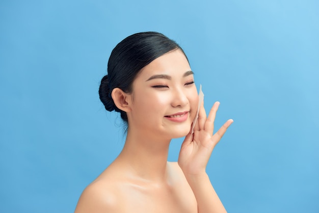 Skin Care. Woman Removing Oil From Face Using Blotting Papers.