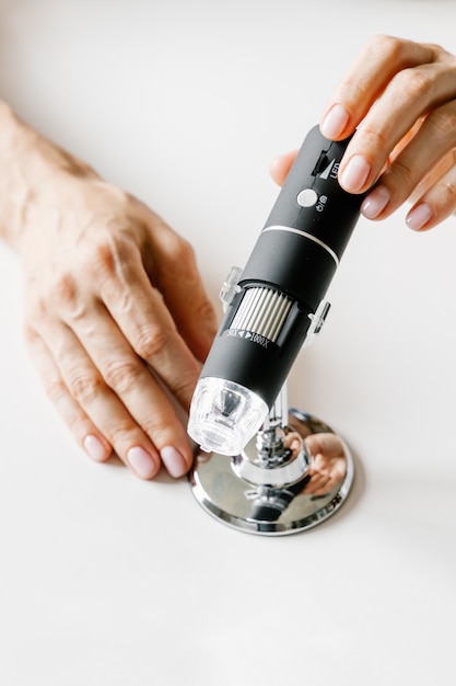 Skin microscope in woman's hands. Modern cosmetology.