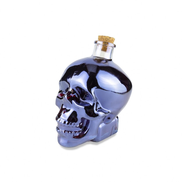 Skull shaped glass bottle with cork with purple liquid inside isolated on white background