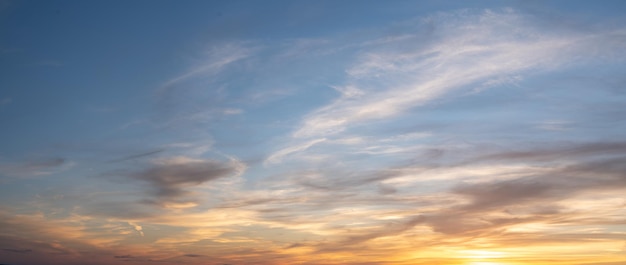 Sky sunset Real amazing panoramic sunrise or sunset sky with gentle colorful clouds wide panorama Panorama of orange sunset sky with bright sun