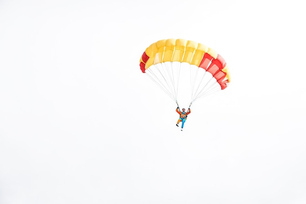 Skydiver with colorful parachute descends towards the earth