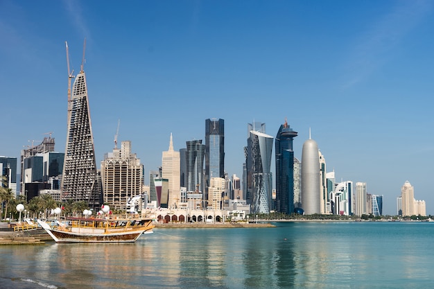 Skyscrapers in the city center with water and boat foreground of Doha, Qatar .