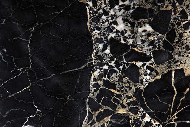 A slab of dark expensive marble with yellow streaks, called New Portoro.