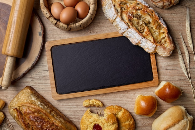 Photo slate board with breads on wooden table