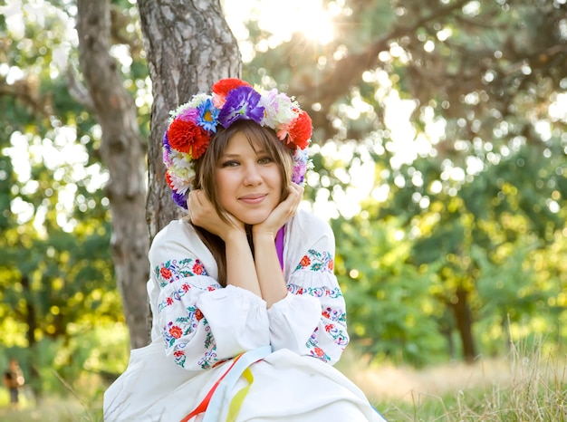 Slav girl with wreath at field.