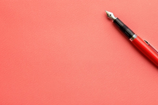 Photo a sleek contact management list lies on a smooth coral surface accompanied by a classic fountain pen poised for writing