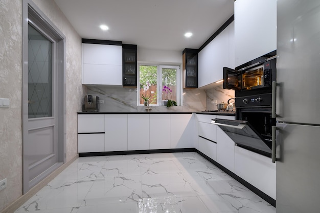 A sleek modern kitchen with white cabinets a marble floor