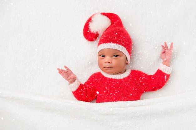 Sleeper newborn baby in a Christmas Santa cap